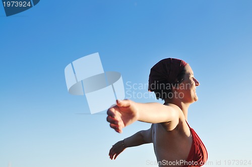 Image of happy girl spreading hands and enjoy in sunlight
