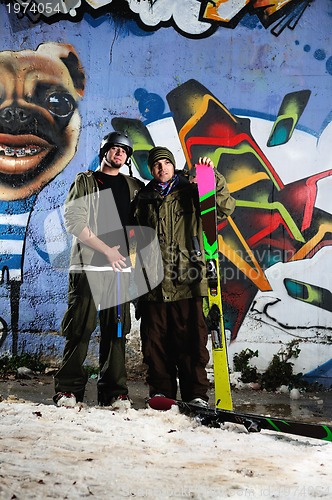 Image of two skiirs standing against colorful background