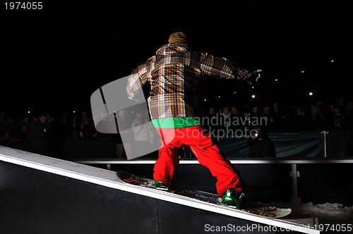 Image of freestyle snowboarder jump in air at night