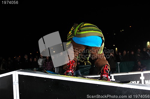 Image of freestyle snowboarder jump in air at night