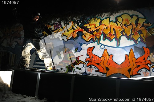 Image of freestyle snowboarder jump in air at night