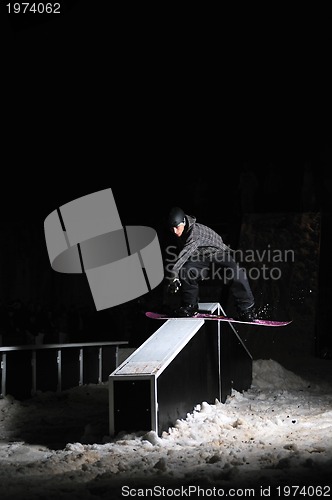 Image of freestyle snowboarder jump in air at night