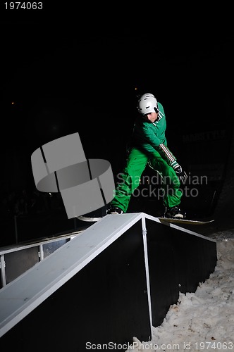 Image of freestyle snowboarder jump in air at night