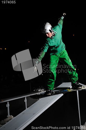 Image of freestyle snowboarder jump in air at night