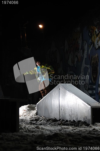 Image of freestyle snowboarder jump in air at night