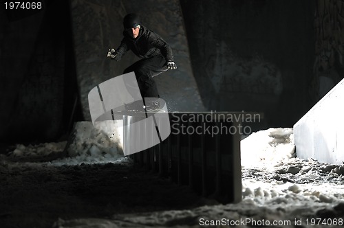 Image of freestyle snowboarder jump in air at night