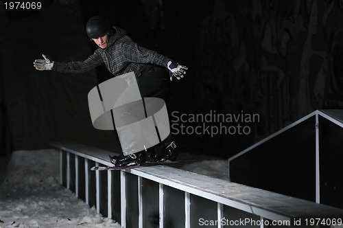 Image of freestyle snowboarder jump in air at night