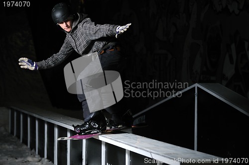 Image of freestyle snowboarder jump in air at night