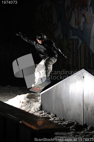 Image of freestyle snowboarder jump in air at night