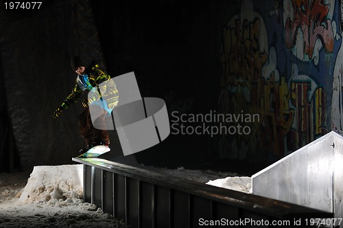 Image of freestyle snowboarder jump in air at night