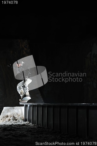 Image of freestyle snowboarder jump in air at night