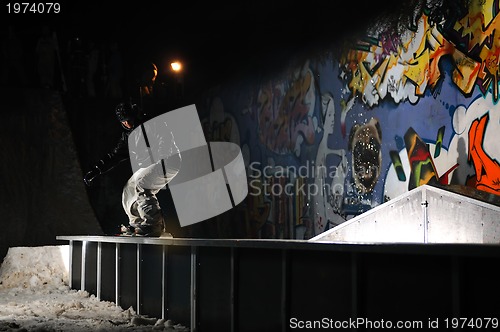 Image of freestyle snowboarder jump in air at night