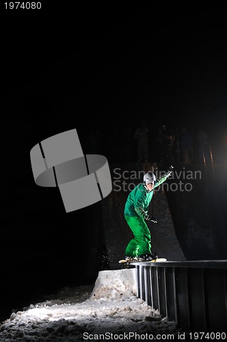 Image of freestyle snowboarder jump in air at night