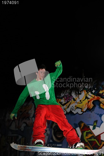 Image of freestyle snowboarder jump in air at night