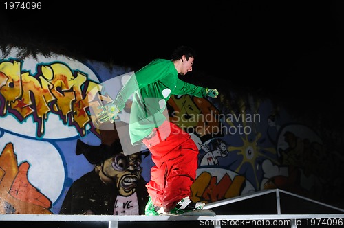 Image of freestyle snowboarder jump in air at night