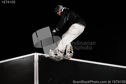 Image of freestyle snowboarder jump in air at night