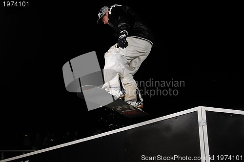 Image of freestyle snowboarder jump in air at night