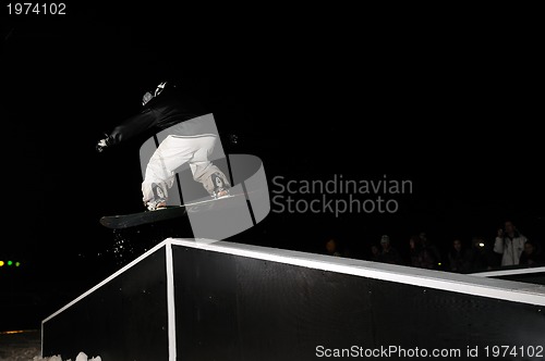Image of freestyle snowboarder jump in air at night