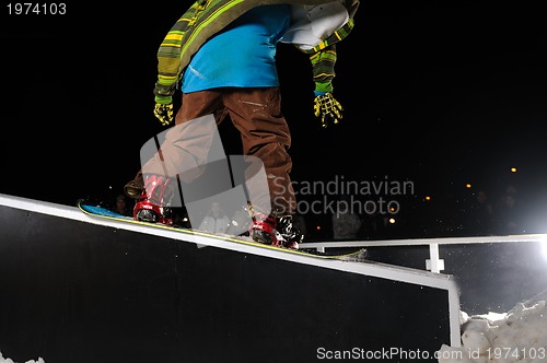 Image of freestyle snowboarder jump in air at night