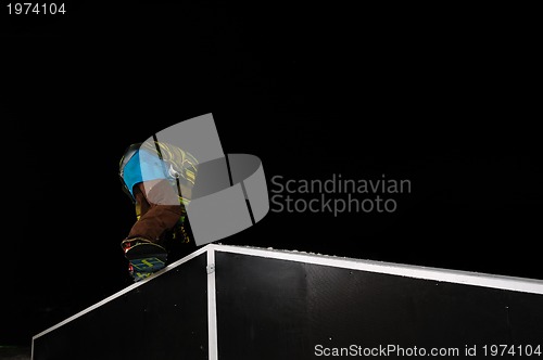 Image of freestyle snowboarder jump in air at night