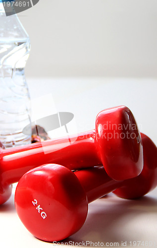 Image of Red dumbbells and bottle of water