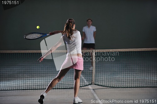 Image of young girls playing tennis game indoor