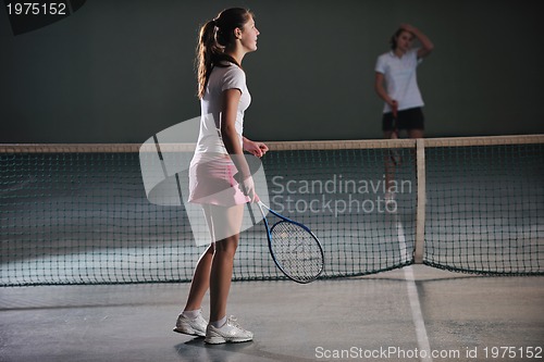 Image of young girls playing tennis game indoor