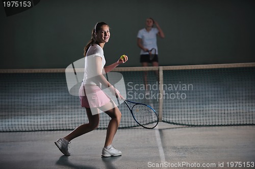 Image of young girls playing tennis game indoor