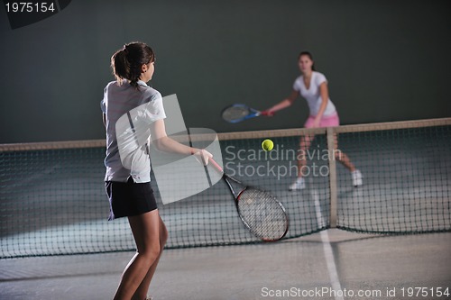 Image of young girls playing tennis game indoor