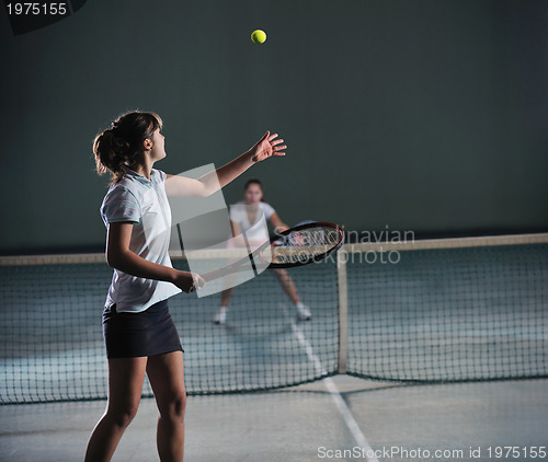 Image of young girls playing tennis game indoor