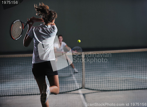 Image of young girls playing tennis game indoor