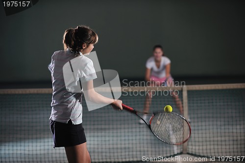 Image of young girls playing tennis game indoor