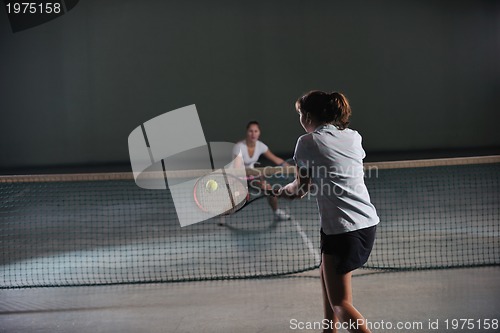 Image of young girls playing tennis game indoor