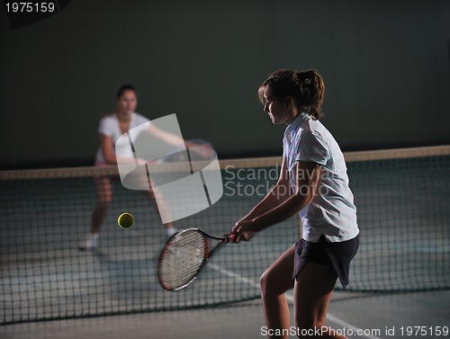 Image of young girls playing tennis game indoor