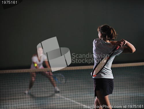 Image of young girls playing tennis game indoor