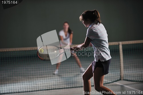 Image of young girls playing tennis game indoor