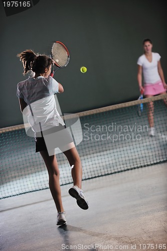Image of young girls playing tennis game indoor