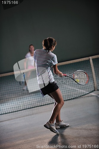 Image of young girls playing tennis game indoor