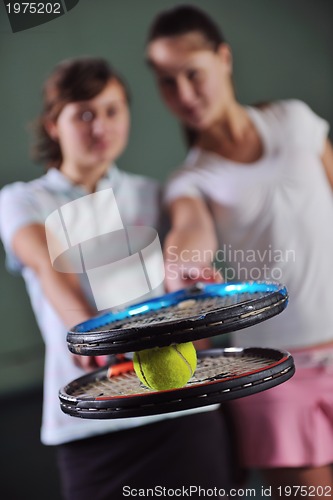 Image of young girls playing tennis game indoor