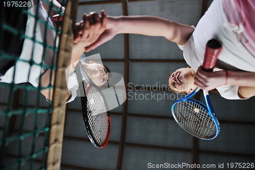 Image of young girls playing tennis game indoor