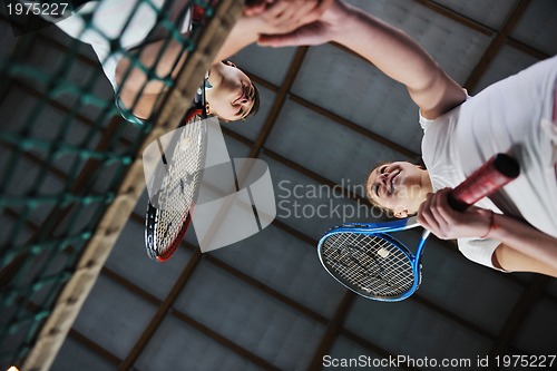 Image of young girls playing tennis game indoor