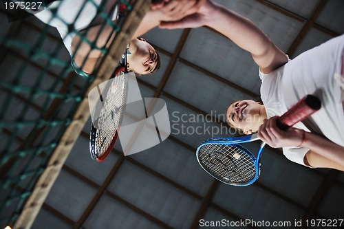 Image of young girls playing tennis game indoor