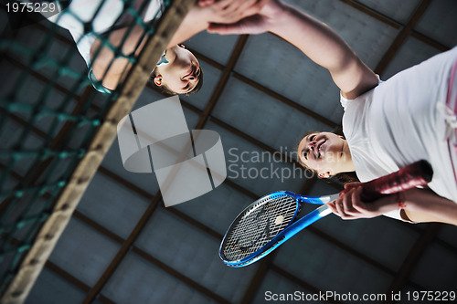 Image of young girls playing tennis game indoor