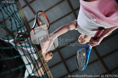 Image of young girls playing tennis game indoor