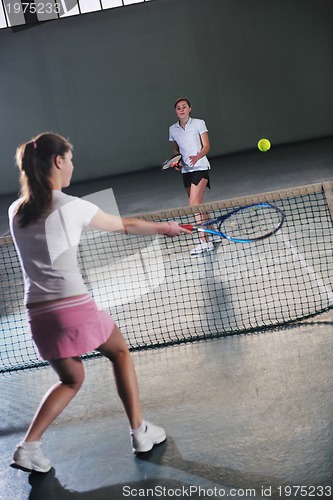 Image of young girls playing tennis game indoor