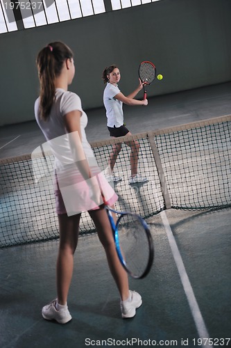 Image of young girls playing tennis game indoor
