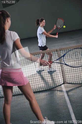 Image of young girls playing tennis game indoor
