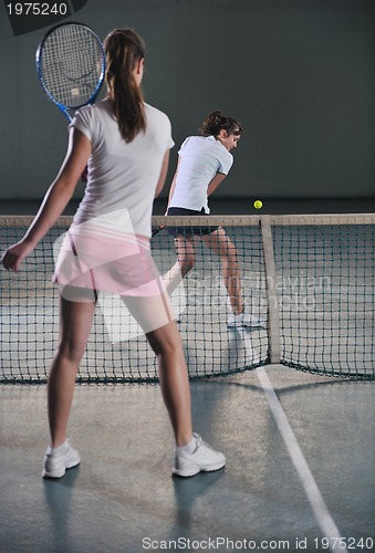 Image of young girls playing tennis game indoor