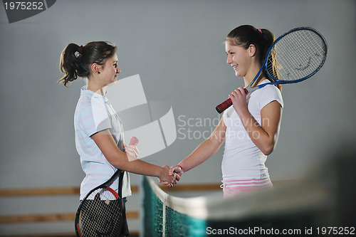 Image of young girls playing tennis game indoor