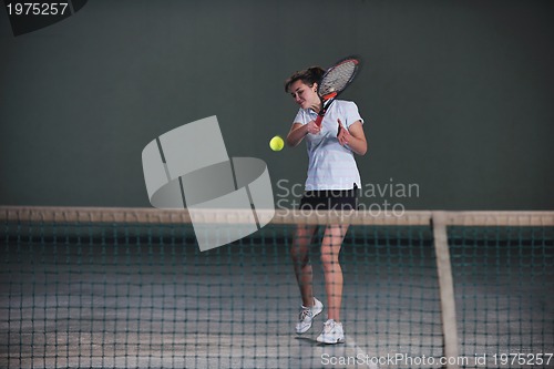 Image of young girls playing tennis game indoor